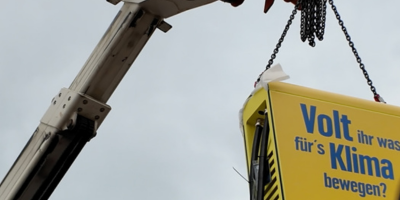 Ein EDEKA-Schnelllader hängt an einem Kran